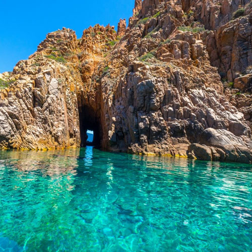 Montagnes de rochers rouges qui contrastent avec l'océan bleu